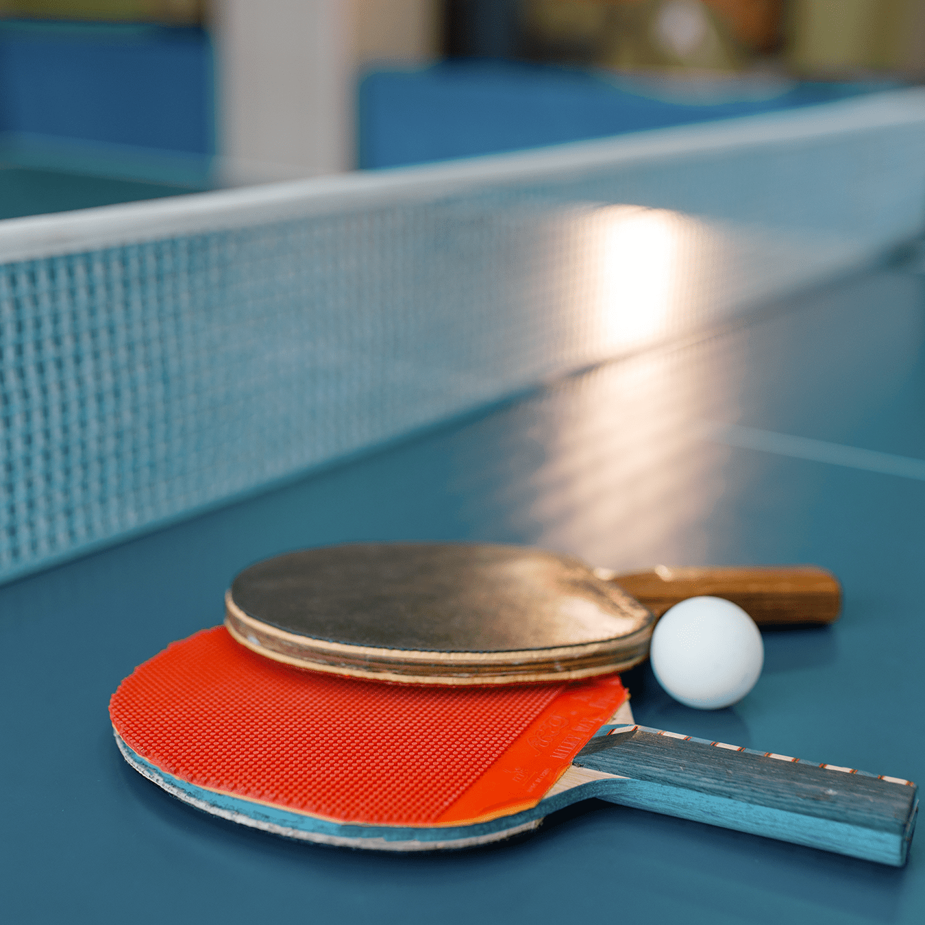 two-ping-pong-paddles-on-the-table-with-net-2026-01-06-10-08-04-utc
